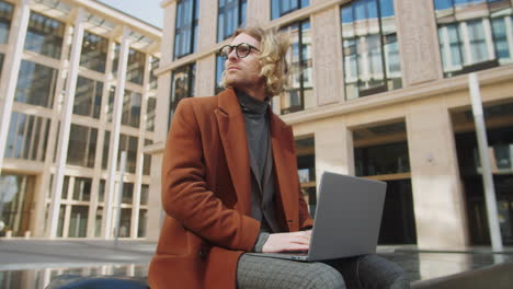 Young-Businessman-Working-on-Laptop-Outdoors-in-City