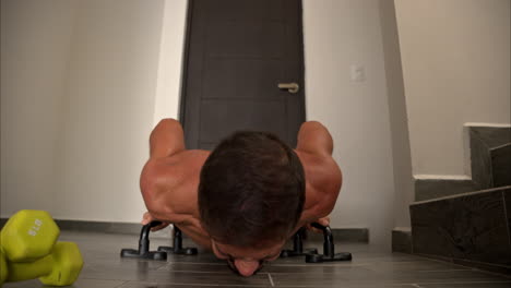 Slow-motion-close-up-of-a-latin-hispanic-fit-man-in-his-40s-doing-a-home-exercise-workout-performing-push-ups