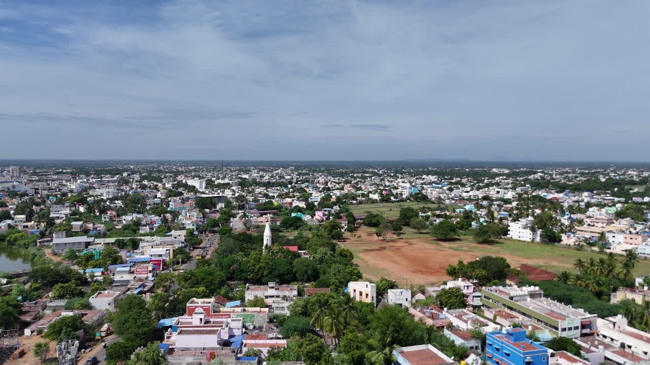 Cityscape showcasing Pudukkottai's typical urban landscape with various buildings and tree cover.