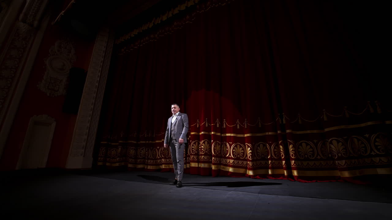 Man on stage in theater. Man speaking on stage of theatre
