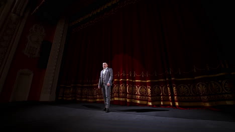 man on stage in theater. man speaking on stage of theatre