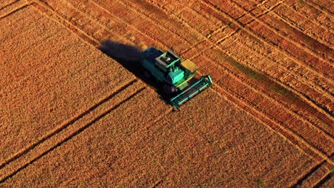 combine harvester on wheat field in the countryside of lithuania - aerial shot