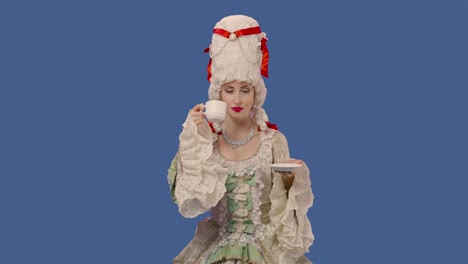 portrait of courtier lady in white vintage lace dress and wig, drinking coffee from a cup. young woman posing in studio with blue screen background. close up. slow motion ready 59.94fps