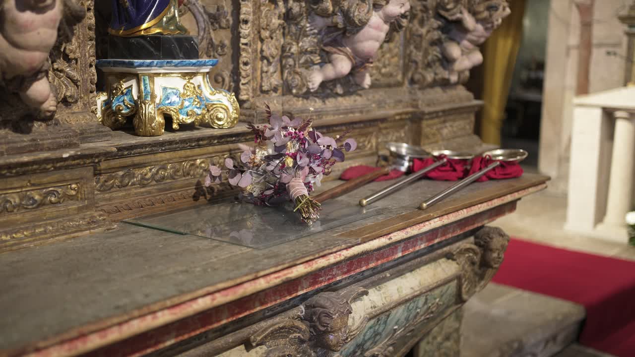 Ornate altar with a floral bouquet and ceremonial tools resting on its surface