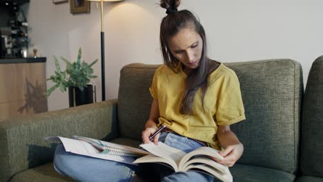 enfoque mujer caucásica estudiando en casa sentada en el sofá