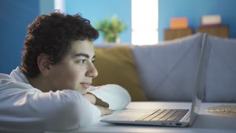 un niño feliz y alegre mirando la computadora portátil con atención.
