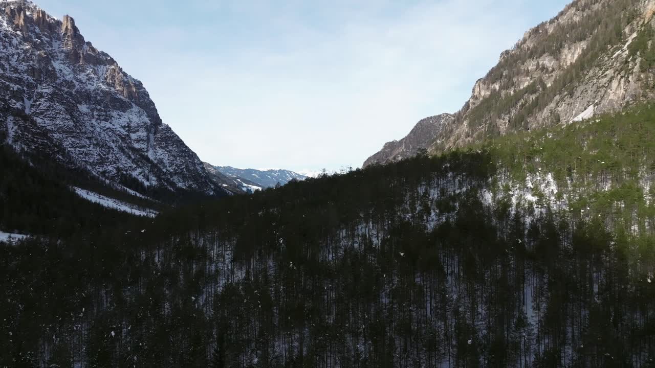 vista aérea ascendente sobre el bosque del valle a la sombra con paisaje invernal en marebbe
