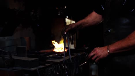 Mid-section-of-blacksmith-selecting-tools