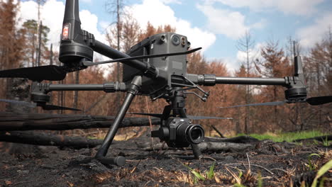 dron quadcopter dji matrice con cámara en suelo quemado del bosque, de cerca