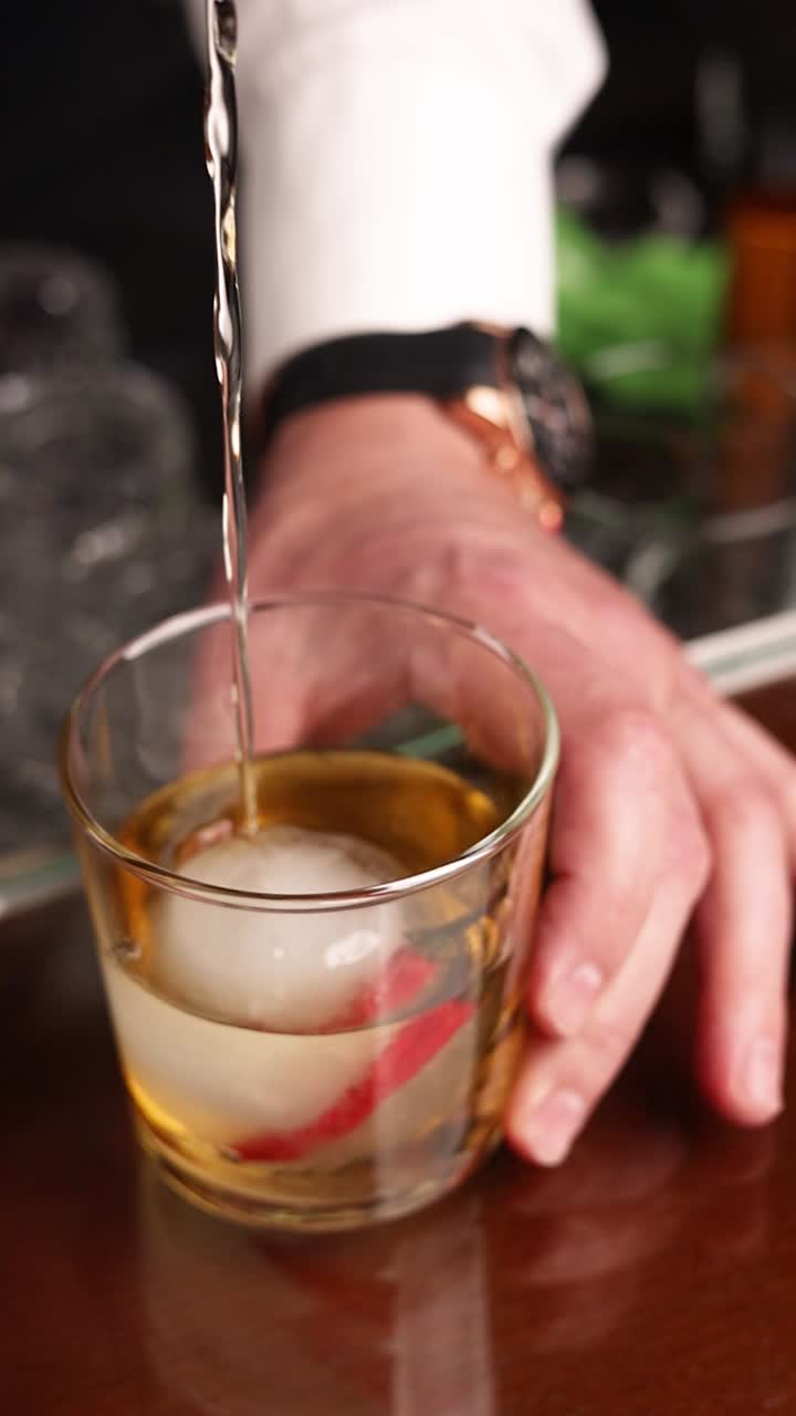 Bartender pouring whiskey cocktail