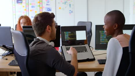 Side-view-of-young-cool-mixed-race-business-team-planning-and-sitting-at-desk-in-a-modern-office-4k