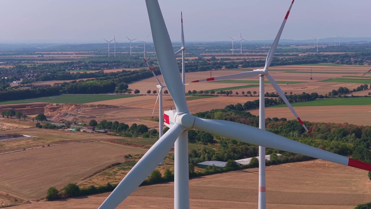 Vista aerea di pale eoliche in rotazione in un paesaggio rurale