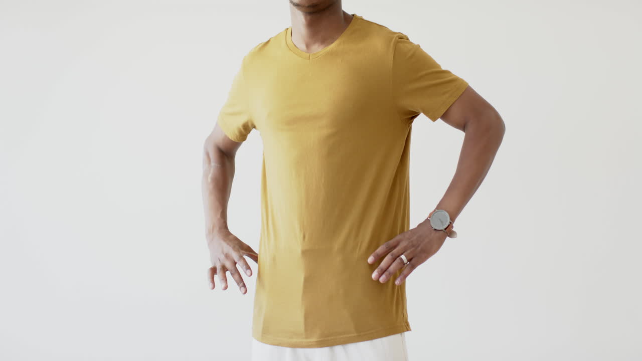 sección media de un hombre afroamericano vestido con una camiseta amarilla con espacio de copia en fondo blanco