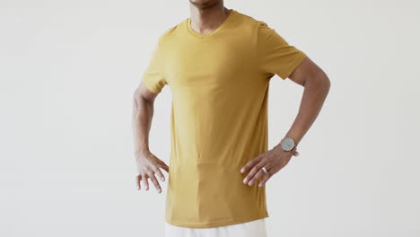 sección media de un hombre afroamericano vestido con una camiseta amarilla con espacio de copia en fondo blanco
