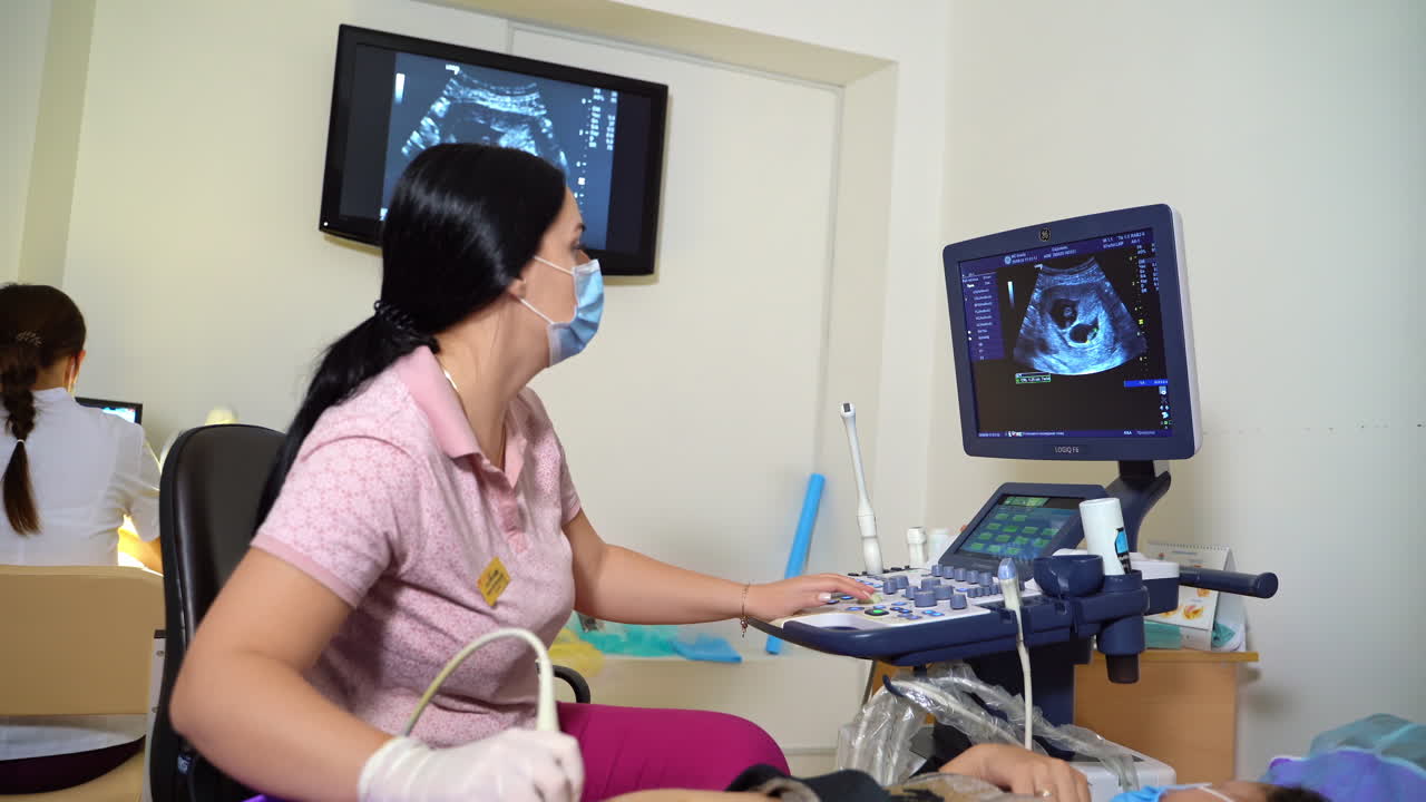Doctor scans abdomen of a little boy with medical utlrasound. Cute teenage being diagnosed with an ultrasound device in a hospital.
