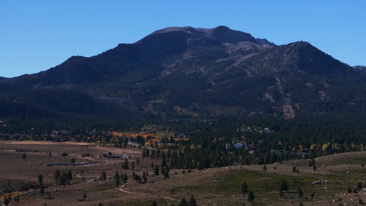Old Main Street Mammoth Mountain Lakes Ski Area Sierras aerial drone California summer autumn fall Aspen Trees sunny blue sky Inyo National Forest downtown Main Lodge McCoy Station forward motion