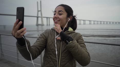 happy hindu woman having video call through smartphone