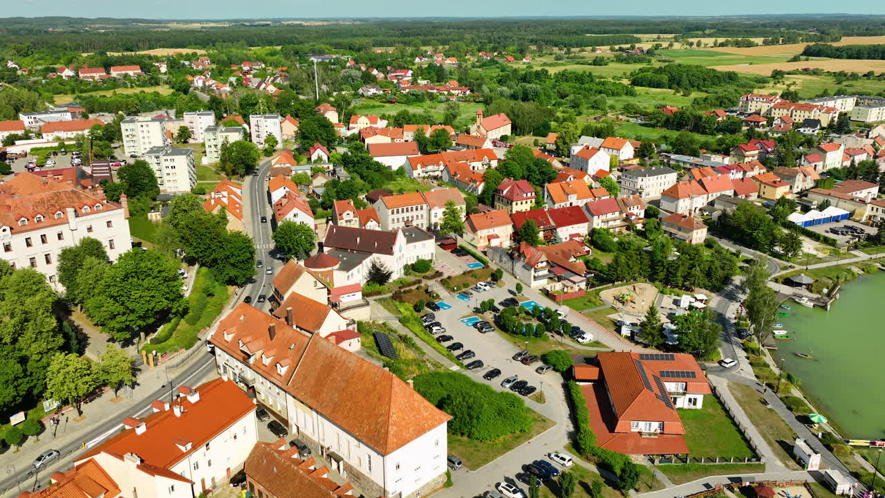 Vista aerea della città di Ryn, Varmia-Masuria, che mostra i suoi edifici con tetti rossi, il porto turistico e il lago verde.