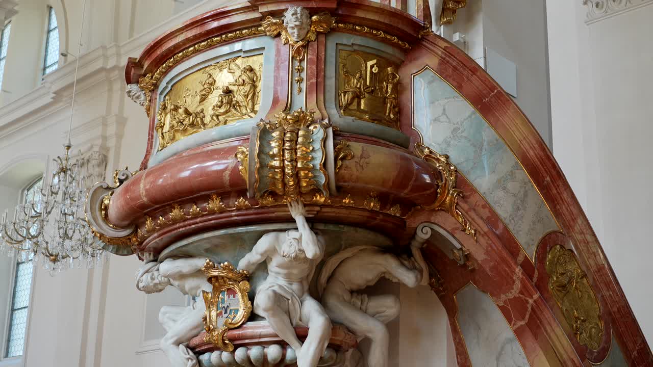 Visão em close-up das decorações e esculturas douradas no púlpito elevado dentro da basílica
