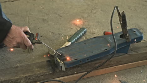 sparks and smoke rising from welding metal in a workshop -close up slow motion