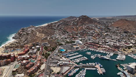 cabo san lucas, mexico, drone shot of marina, beachfront buildings and resorts, rocky hills on sunny day