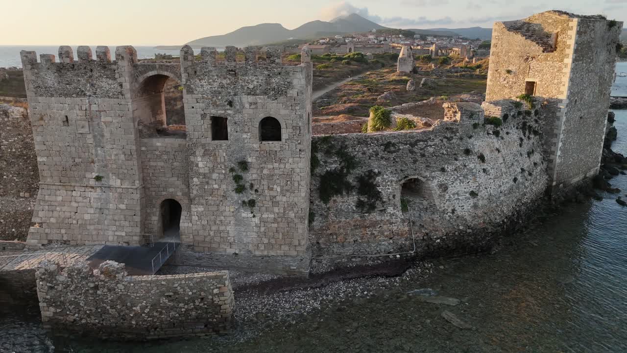 Methoni,Messenia,Peloponnese,Aerial view pan right close up Methoni Castle Towers surrounded by crystal clear waters during golden hour