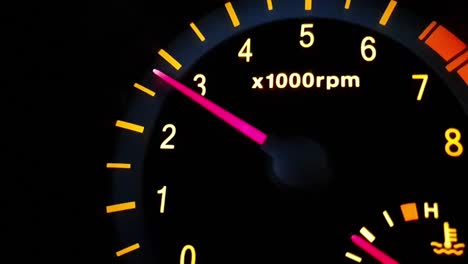 Car-revving-it's-internal-combustion-gasoline-engine-up-to-3000rpm-with-backlit-dial-and-numbers-in-the-dark