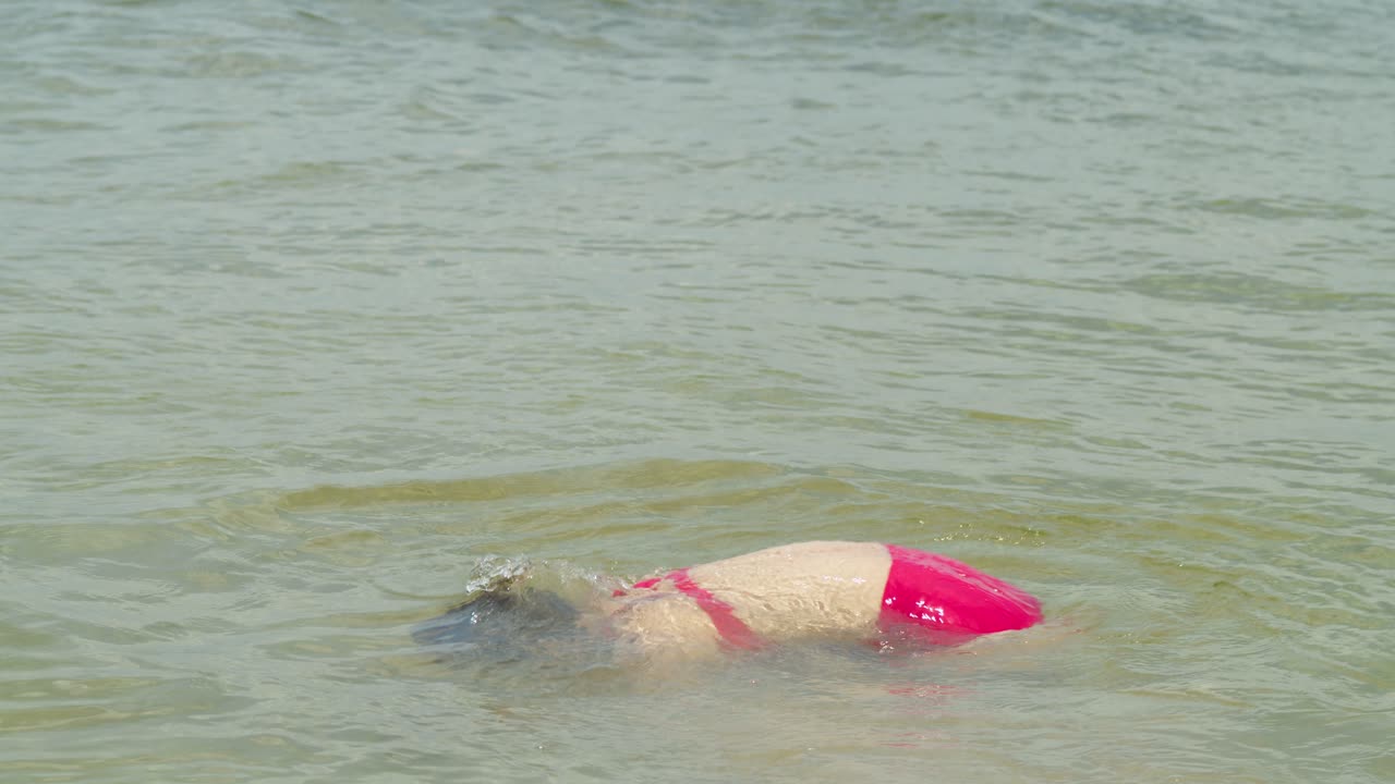 disfrutando del sol y la arena, una chica latina con cabello rizado exuda sensualidad en un traje tropical de playa