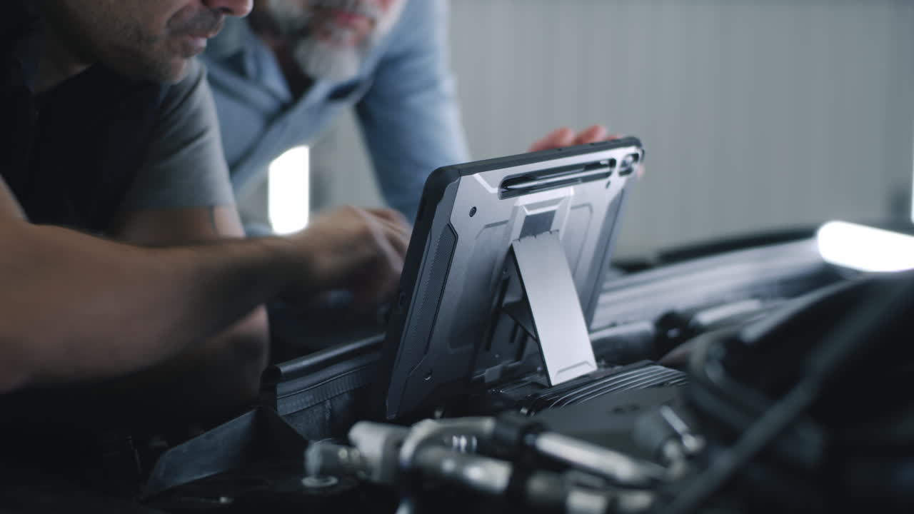 Mechanics Using Tablet for Car Diagnostics