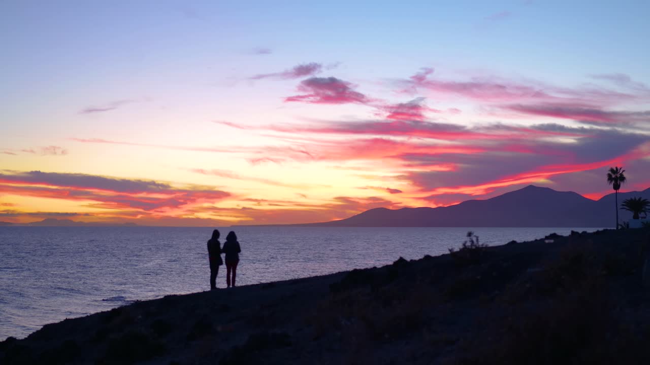 Couple watching sunset over the ocean