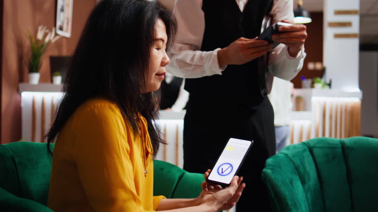 Turista che usa il pagamento NFC per comprare una tazza di caffè dal bar dell'hotel