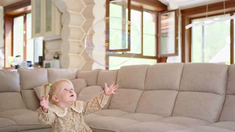 little girl playing with bubbles in a living room