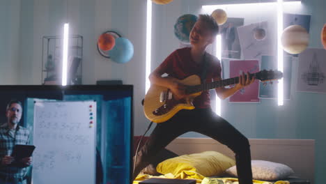 teenager playing guitar in bedroom while online learning