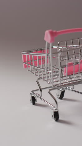 video vertical de un carrito de compras vacío sobre un fondo gris