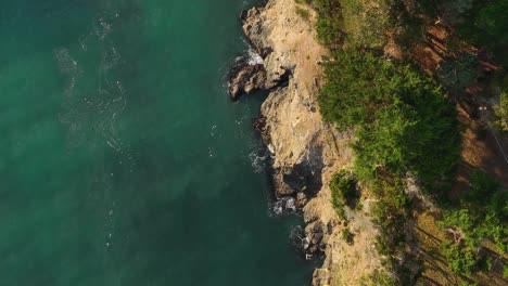Top-down-aerial-view-of-steep-cliffs-overlooking-the-Pacific-Ocean