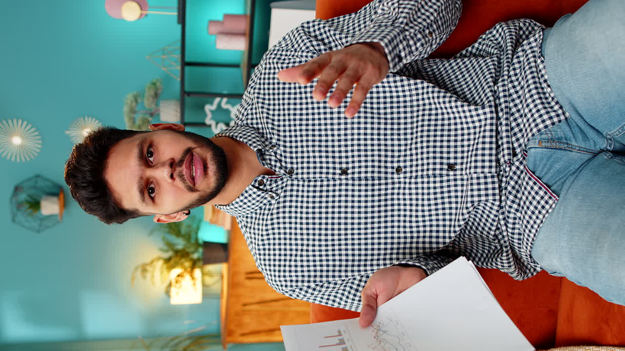 Indian man arguing speaking aggressively during video call showing documents paperwork graph mistake