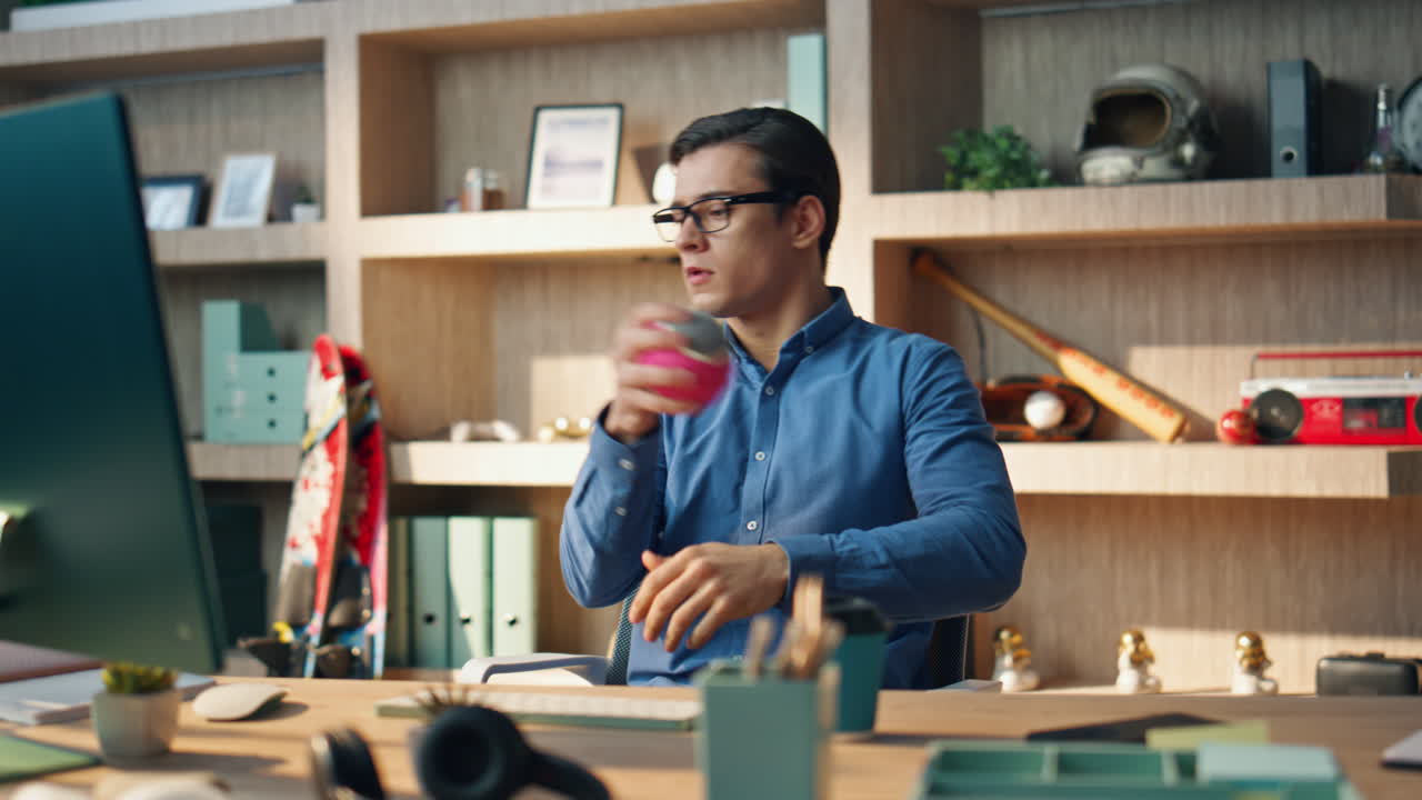 Freelance pensieroso che pensa sul posto di lavoro, primo piano. Uomo d'affari rilassato che lancia una palla