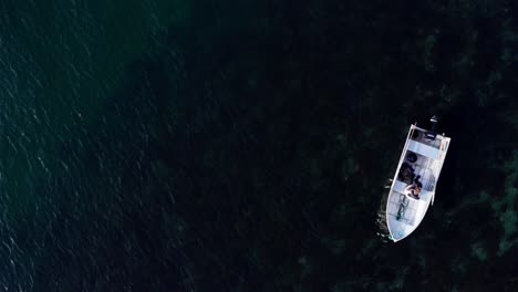 Top-View-Of-A-Person-On-A-Floating-Motor-Boat-On-Tranquil-Lake