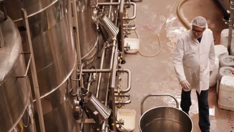 Factory-worker-examining-storage-tanks