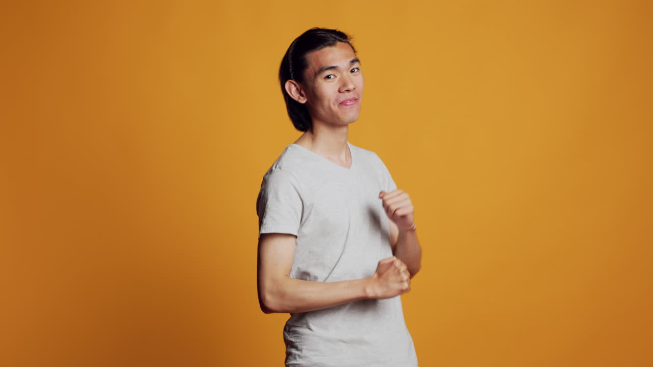 Asian man showing cool dance moves on camera