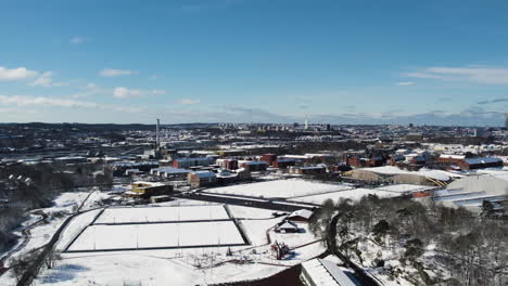 Schneebedeckter-Fußballplatz-Im-Kviberg-Park-Und-Im-Hintergrund-Der-Stadtlandschaft-Von-Göteborg,-Luftaufnahme