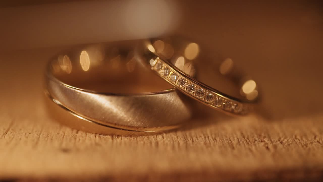 Wedding Rings with diamonds on wooden plate with sparkles
