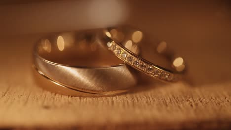 wedding rings with diamonds on wooden plate with sparkles