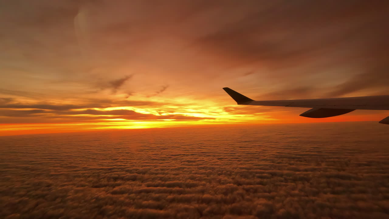 Nascer ou pôr do sol esplêndido visto de um avião, com a asa em silhueta.