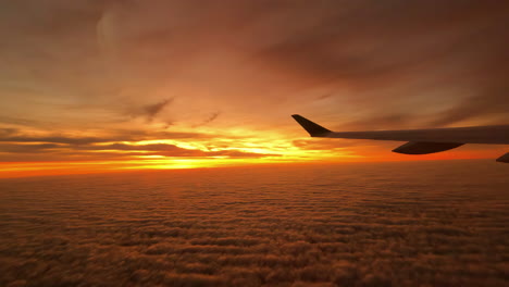 brilliant sunrise or sunset as seen from an airplane with the wing in silhouette