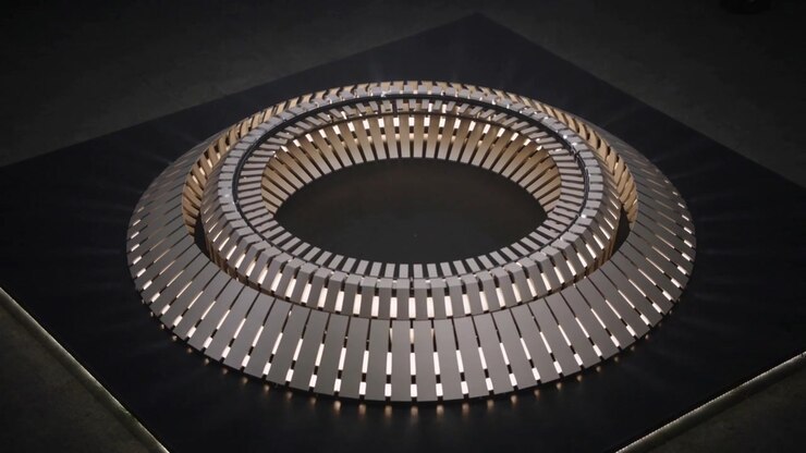 Rotating three concentric metal rings reacting to slots emitting radial beams on black pedestal