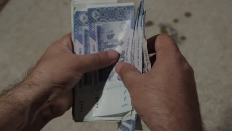 close up of pakistani currency - man hand counting pakistani rupee of 1000