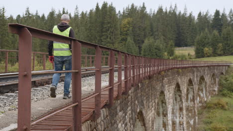 worker walking on a railway bridge