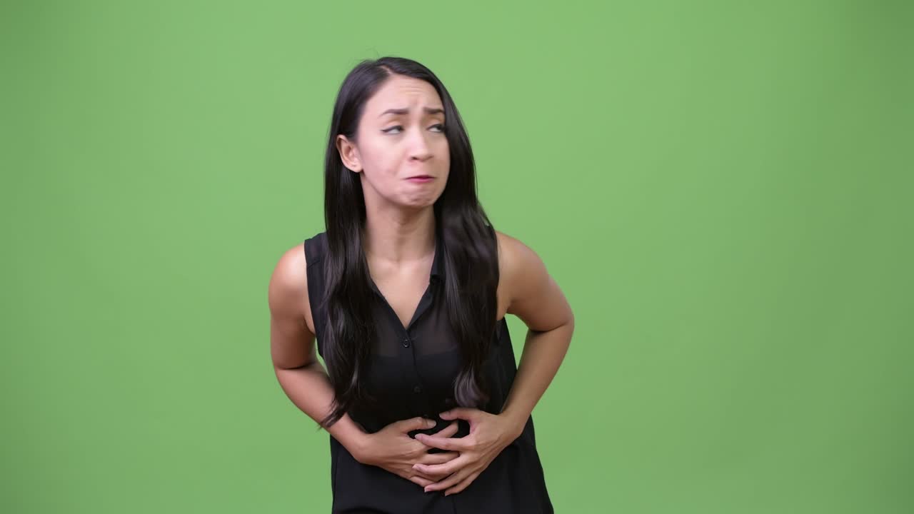 Young beautiful Asian businesswoman having stomach ache