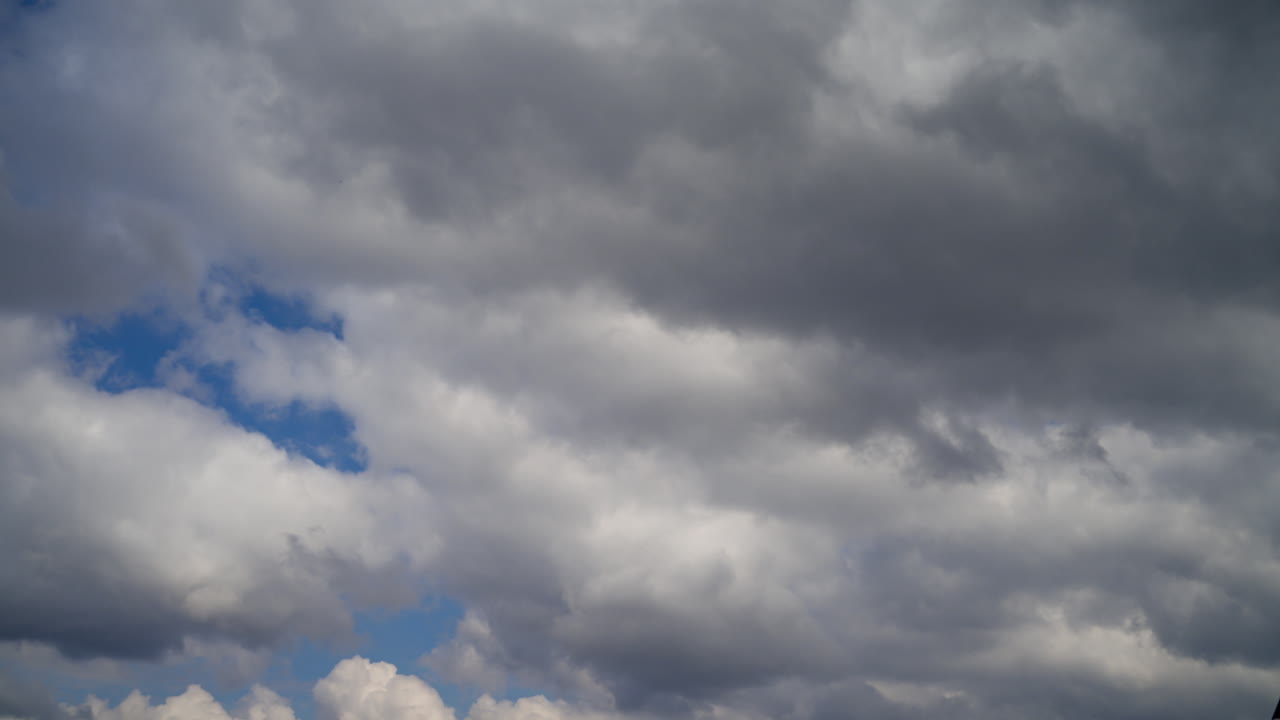 Blue sky with white fluffy cumulus clouds. Rapid movement of clouds in the air. Timelapse